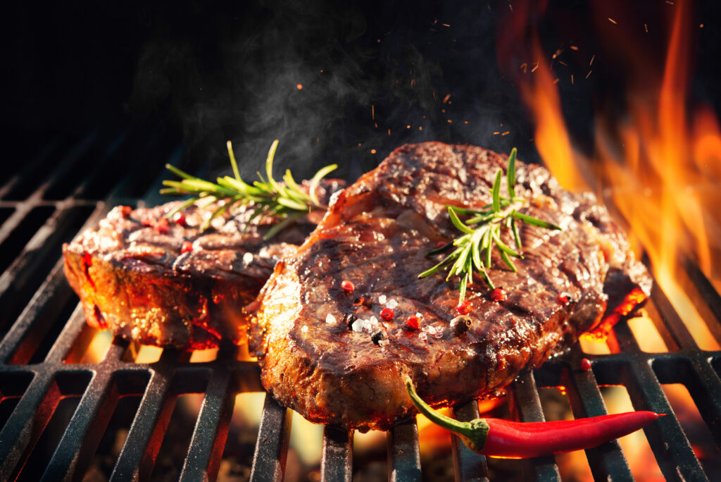 bigstock Beef steaks sizzling on the gr 294363871